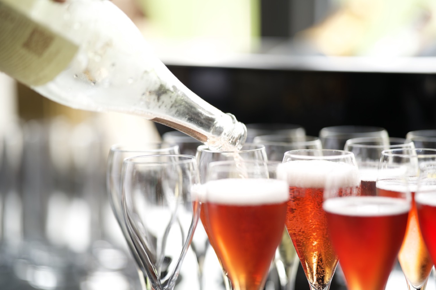 Sekt wird in Reihen roter und heller Flöten eingeschenkt
