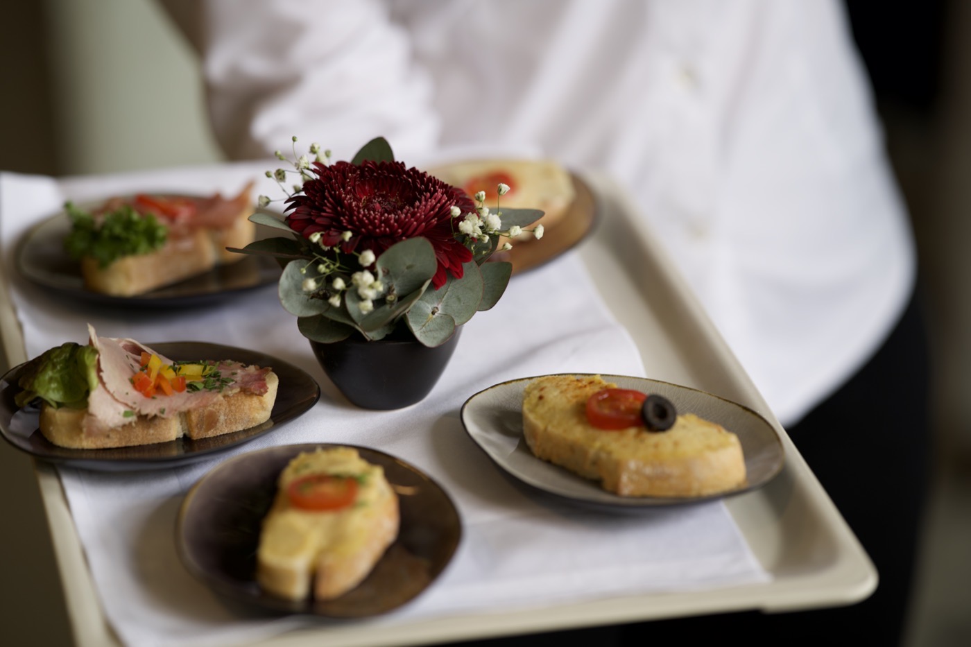 Canapé-Tablett mit Blume, vom Service getragen
