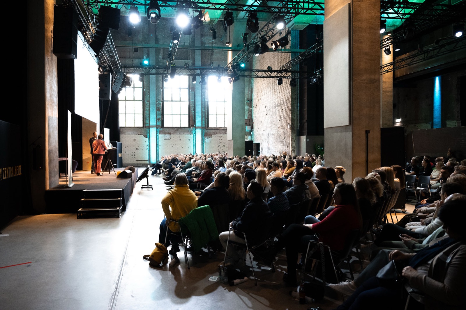 Publikum vor einer Bühne im Kesselsaal der Zentralheize