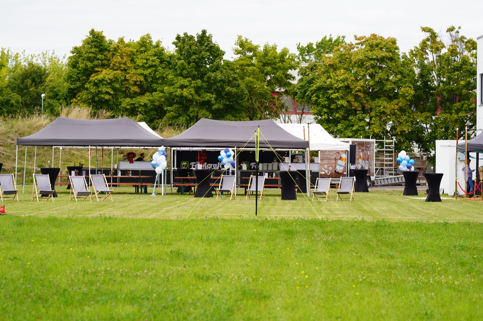Pavillons und Zelte auf einer Wiese vor Veranstaltungsbeginn