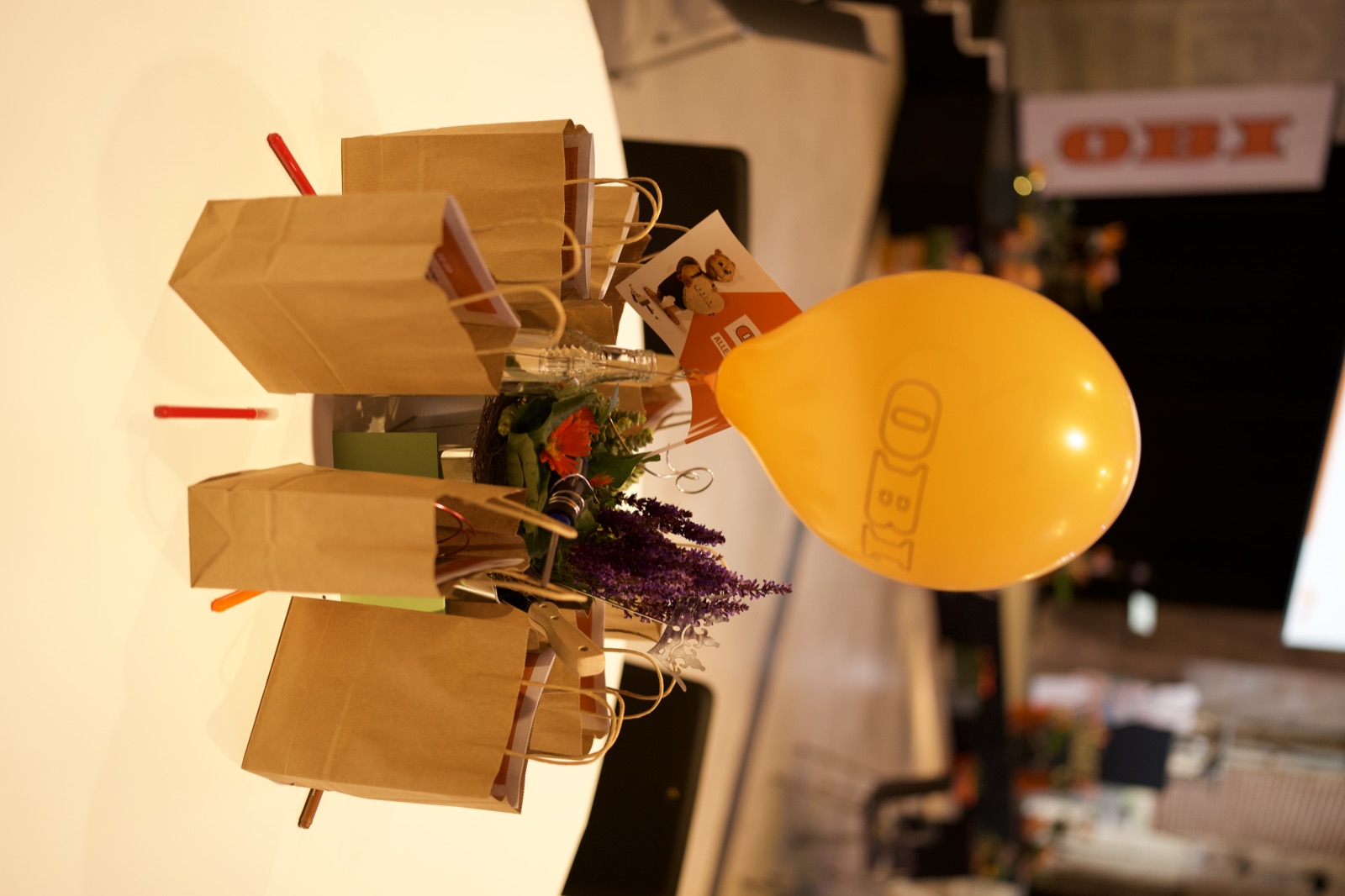 Ein orangefarbener OBI-Ballon und Papiertüten auf einer dekorierten runden Tafel