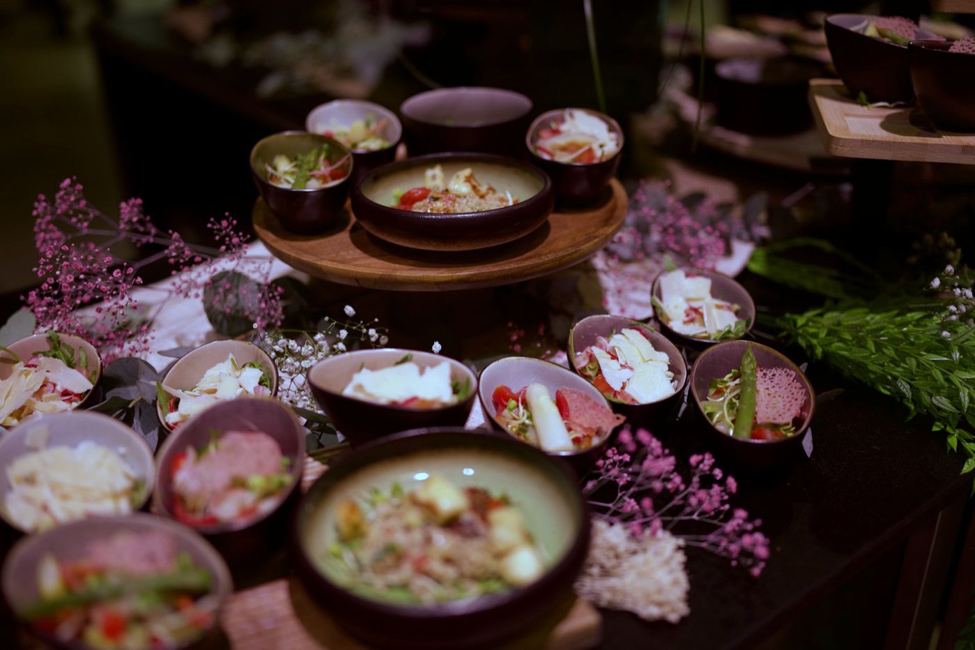 Buffet mit vielen bunten Salatschalen und Blumen