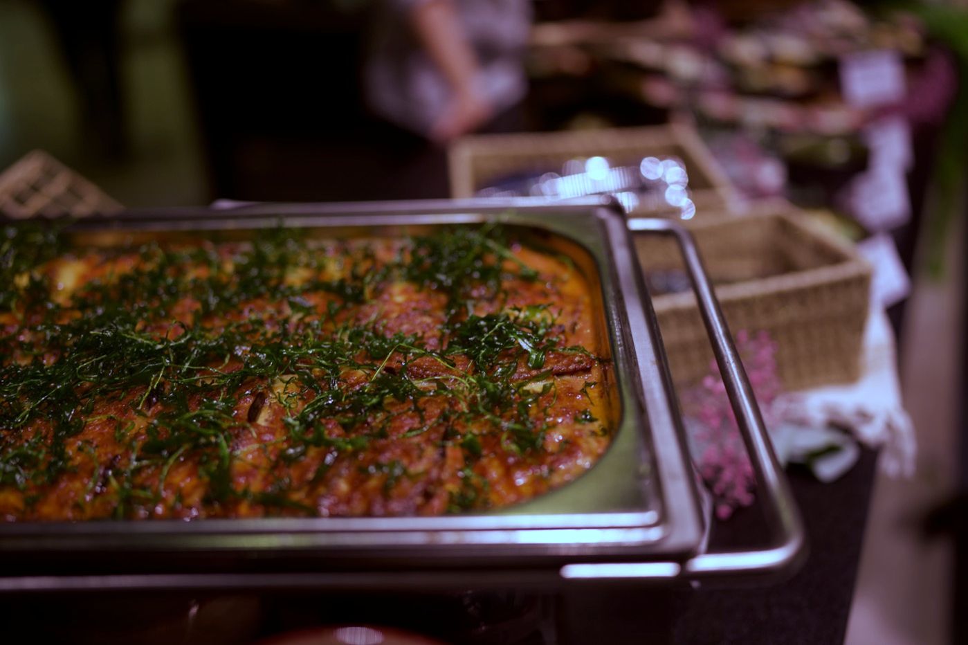 Warmes Gericht mit Tomatensauce und Kräutern im Chafing Dish